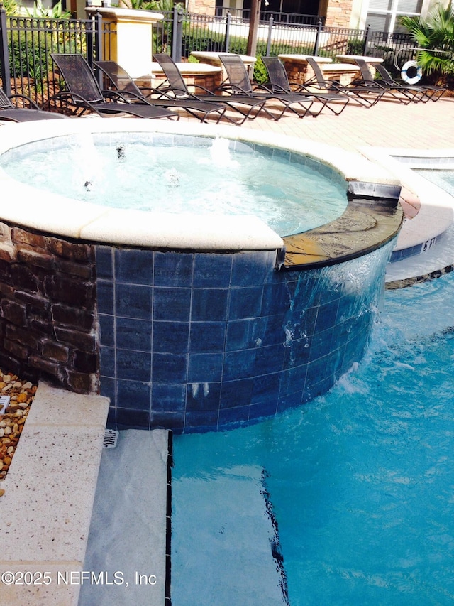 8539 Gate Pkwy W Unit 1616, Jacksonville, FL 32216 - view of swimming pool featuring an in ground hot tub and fence