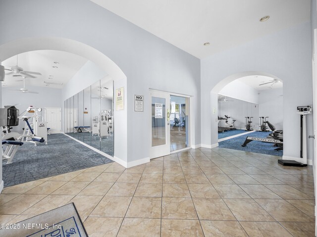 35211 Harbour Vista Cir, Saint Augustine, FL 32080 - interior space featuring baseboards, a ceiling fan, arched walkways, and a towering ceiling