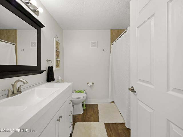 35211 Harbour Vista Cir, Saint Augustine, FL 32080 - bathroom featuring toilet, vanity, wood finished floors, and a textured ceiling