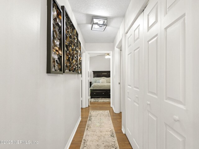 35211 Harbour Vista Cir, Saint Augustine, FL 32080 - hall featuring a textured ceiling, dark wood-style flooring, and baseboards