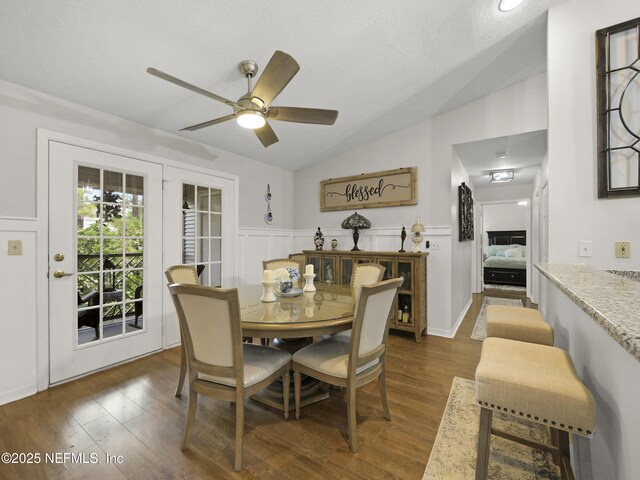 35211 Harbour Vista Cir, Saint Augustine, FL 32080 - dining space featuring a wainscoted wall, ceiling fan, vaulted ceiling, and dark wood-style floors