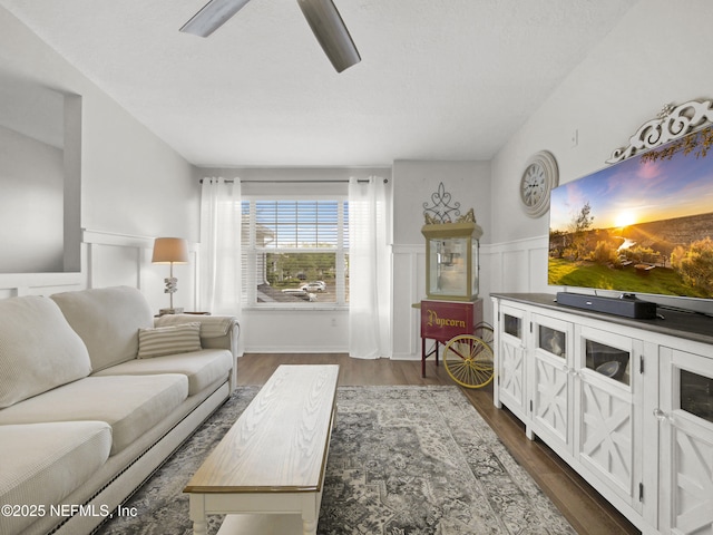 35211 Harbour Vista Cir, Saint Augustine, FL 32080 - living room featuring dark wood-type flooring, wainscoting, a decorative wall, and a ceiling fan