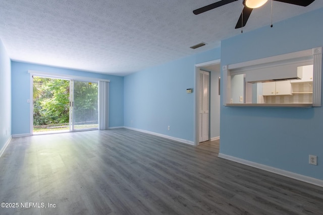 unfurnished living room with dark wood-style flooring, baseboards, a ceiling fan, and a textured ceiling