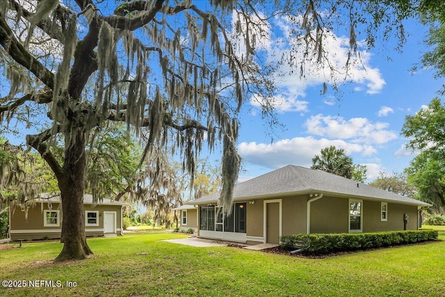 226 Crystal Cove Dr, Palatka, FL 32177 - back of property featuring stucco siding, a sunroom, and a yard