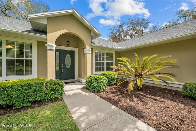 226 Crystal Cove Dr, Palatka, FL 32177 - property entrance with stucco siding and a shingled roof