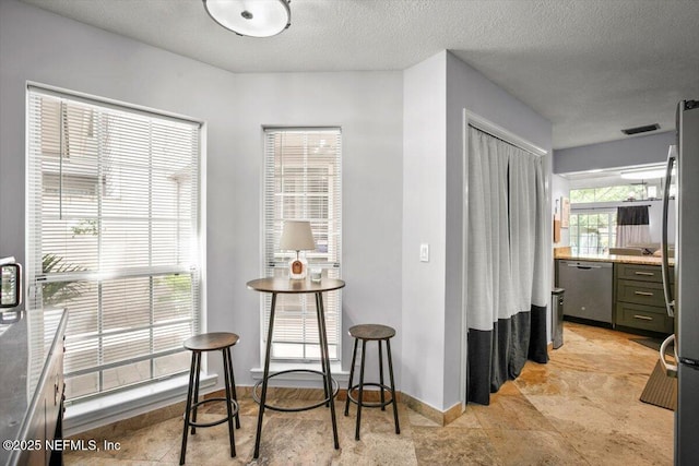 1216 Radis Pl, Jacksonville, FL 32225 - dining area featuring baseboards, a textured ceiling, and visible vents