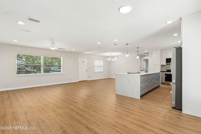 kitchen featuring gray cabinets, recessed lighting, stainless steel appliances, visible vents, and open floor plan