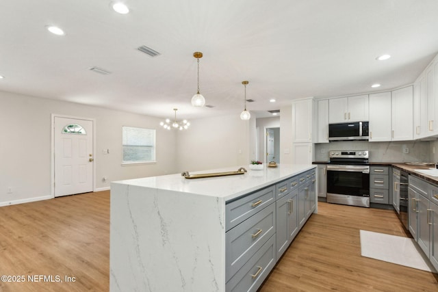 kitchen with recessed lighting, white cabinetry, appliances with stainless steel finishes, gray cabinetry, and visible vents