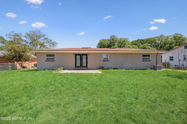 rear view of house featuring fence, french doors, a patio area, and a lawn