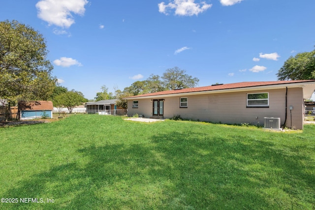 back of house featuring a yard, central AC, and fence