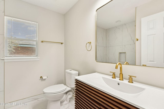 bathroom featuring toilet, marble finish floor, and vanity