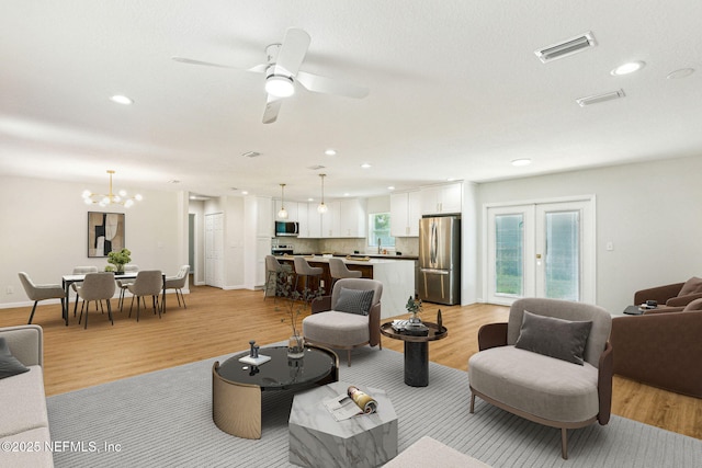 living area with light wood finished floors, recessed lighting, and visible vents