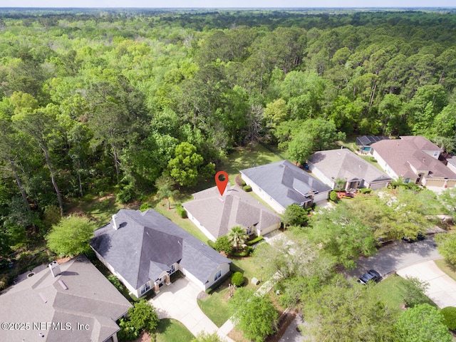 bird's eye view featuring a wooded view and a residential view