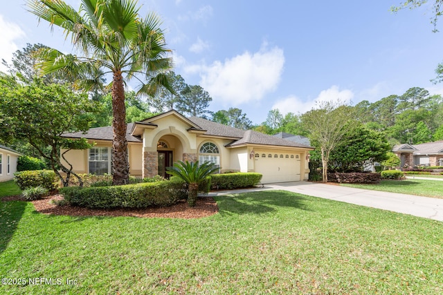 mediterranean / spanish-style home featuring an attached garage, concrete driveway, stucco siding, and a front yard