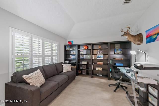 home office with visible vents, a textured ceiling, and lofted ceiling