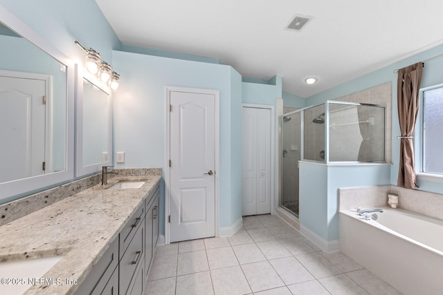 bathroom featuring visible vents, a sink, a shower stall, double vanity, and tile patterned flooring