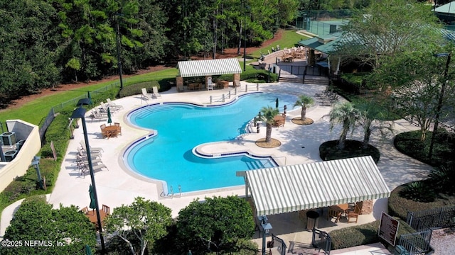 pool featuring fence, a patio, and outdoor dry bar