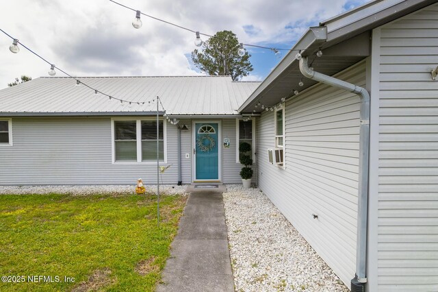 111 Magnolia Dr, East Palatka, FL 32131 - view of exterior entry featuring metal roof and a yard
