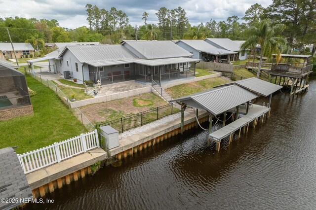 111 Magnolia Dr, East Palatka, FL 32131 - dock area with cooling unit, boat lift, a fenced backyard, a water view, and a lawn