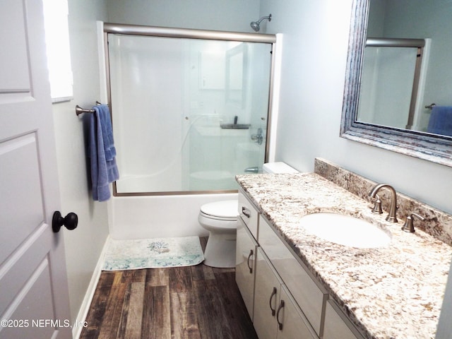 111 Magnolia Dr, East Palatka, FL 32131 - bathroom with vanity, shower / bath combination with glass door, toilet, baseboards, and wood finished floors