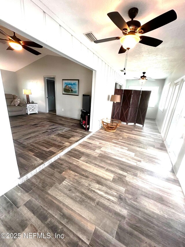 111 Magnolia Dr, East Palatka, FL 32131 - unfurnished living room featuring vaulted ceiling, a textured ceiling, visible vents, ceiling fan, and wood finished floors