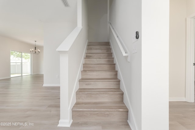 2895 Cross Creek Dr, Green Cove Springs, FL 32043 - staircase featuring baseboards, visible vents, wood finished floors, and a chandelier