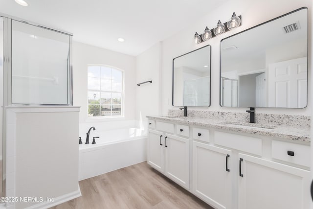 2895 Cross Creek Dr, Green Cove Springs, FL 32043 - full bathroom featuring a bath, double vanity, a sink, and wood finished floors