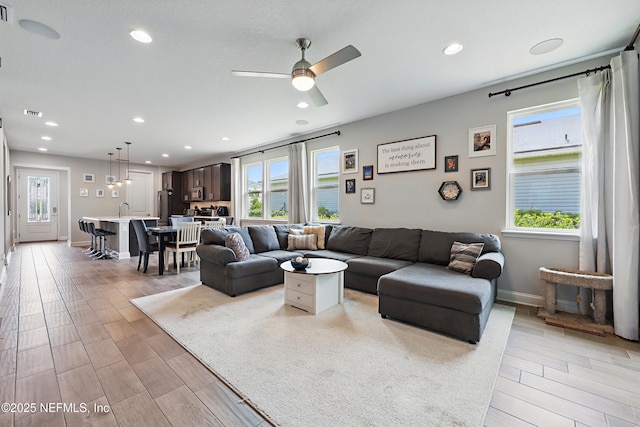 living room featuring light wood-type flooring, a wealth of natural light, recessed lighting, and ceiling fan
