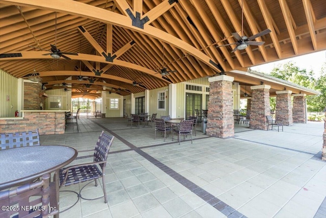 view of patio with ceiling fan, an outdoor bar, and outdoor dining area