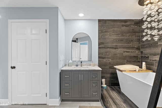 1478 Riverplace Blvd Unit 803, Jacksonville, FL 32207 - bathroom featuring vanity, an accent wall, wooden walls, wood tiled floor, and a freestanding bath