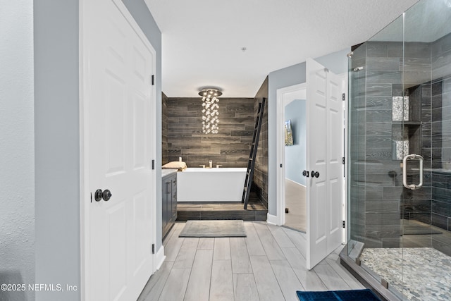 1478 Riverplace Blvd Unit 803, Jacksonville, FL 32207 - bathroom with a shower stall, a soaking tub, and wood finish floors