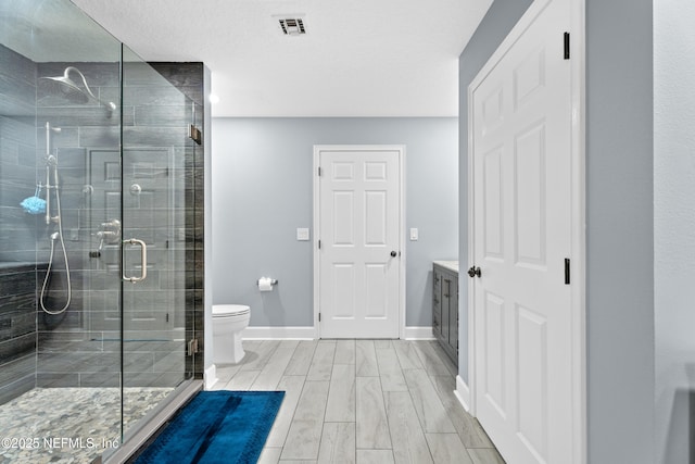 1478 Riverplace Blvd Unit 803, Jacksonville, FL 32207 - bathroom featuring toilet, baseboards, a stall shower, visible vents, and wood tiled floor