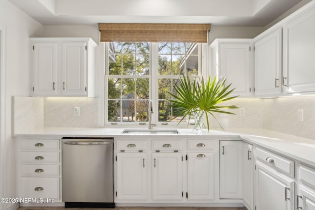 kitchen with white cabinets, dishwasher, a sink, and backsplash