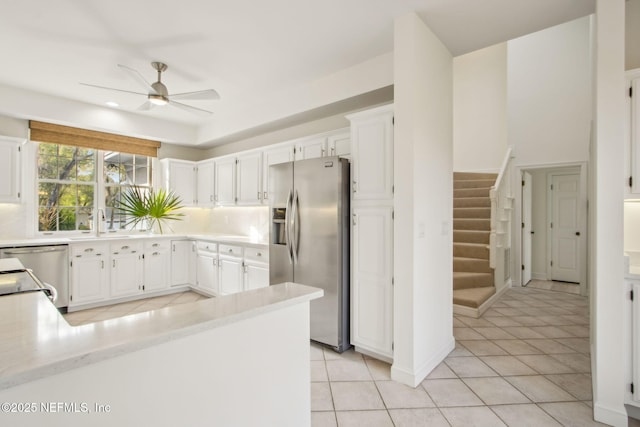 kitchen with a ceiling fan, light tile patterned flooring, white cabinetry, light countertops, and appliances with stainless steel finishes