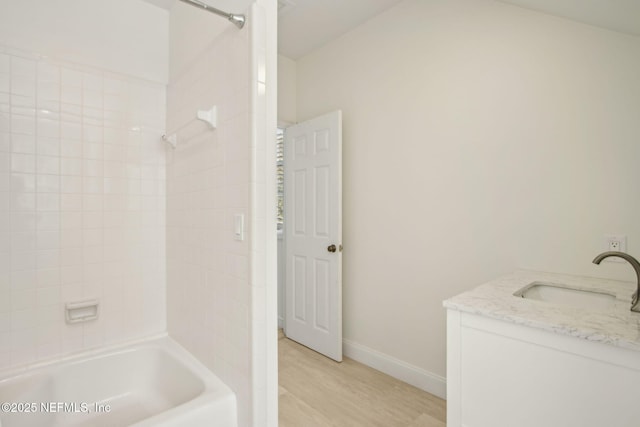 full bathroom with baseboards, vanity, wood finished floors, and tub / shower combination