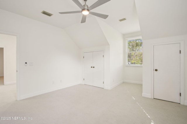 additional living space featuring light carpet, vaulted ceiling, baseboards, visible vents, and ceiling fan