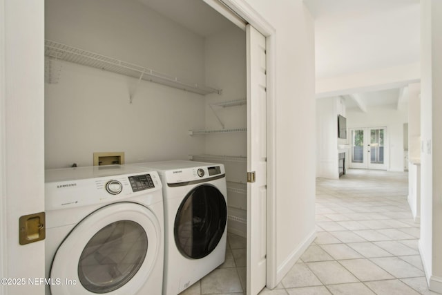 clothes washing area featuring light tile patterned floors, baseboards, laundry area, and independent washer and dryer