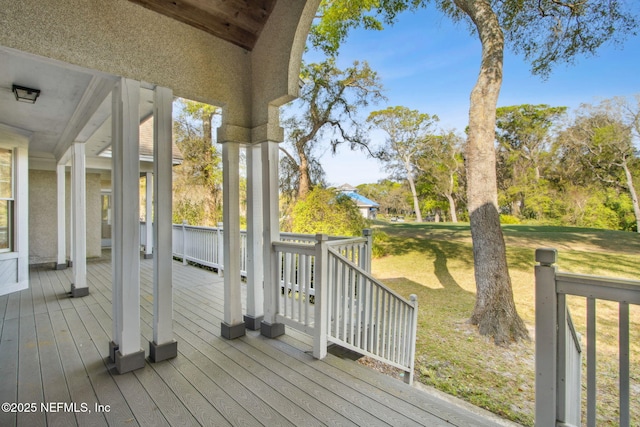 wooden terrace featuring a lawn
