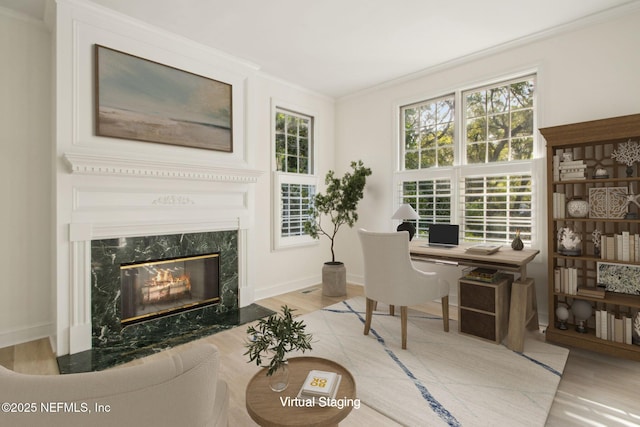 office area featuring baseboards, crown molding, wood finished floors, and a premium fireplace