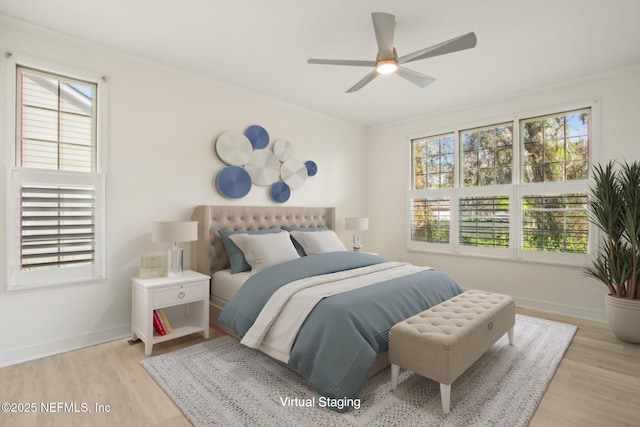 bedroom with baseboards, wood finished floors, and multiple windows