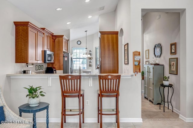 714 Copperhead Cir, Saint Augustine, FL 32092 - kitchen with light countertops, stainless steel appliances, brown cabinetry, and a peninsula