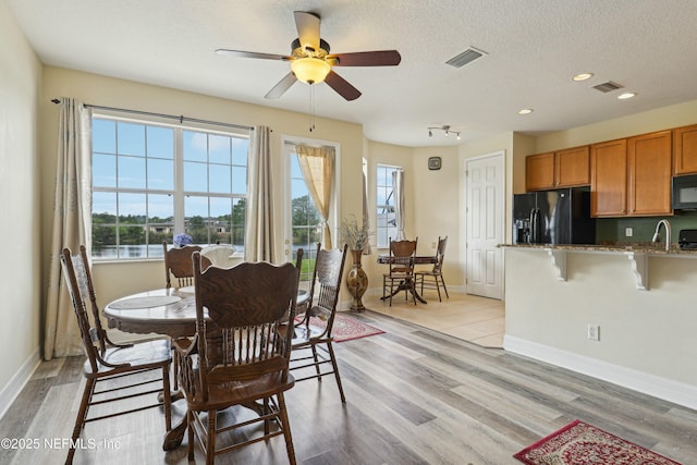 535 Hedgewood Dr, Saint Augustine, FL 32092 - dining area featuring light wood-type flooring, a textured ceiling, a healthy amount of sunlight, and visible vents