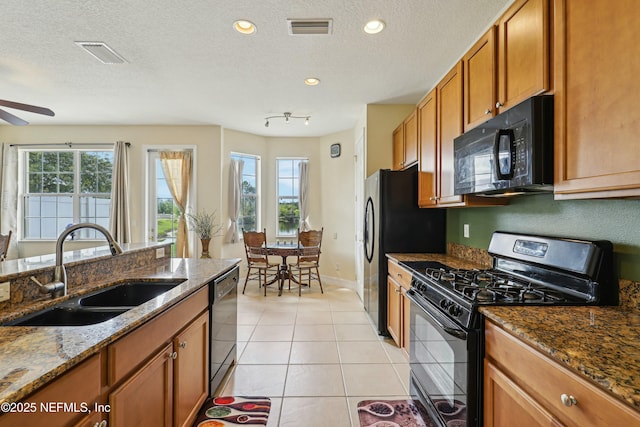 535 Hedgewood Dr, Saint Augustine, FL 32092 - kitchen featuring light tile patterned flooring, a sink, brown cabinetry, visible vents, and black appliances