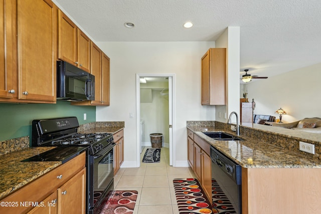 535 Hedgewood Dr, Saint Augustine, FL 32092 - kitchen with light tile patterned flooring, a peninsula, dark stone counters, a sink, and black appliances