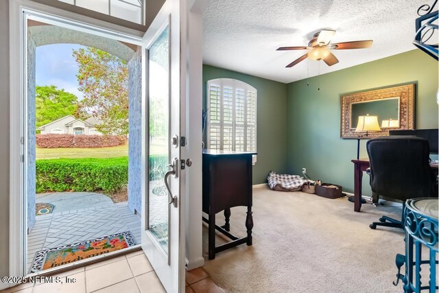 carpeted home office featuring a textured ceiling, baseboards, and ceiling fan