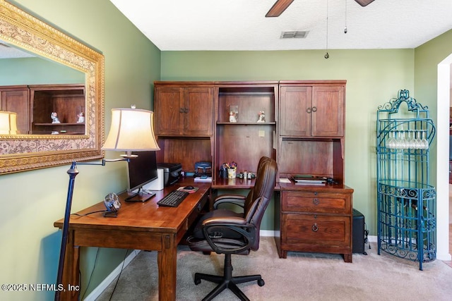 office with visible vents, ceiling fan, light carpet, and baseboards