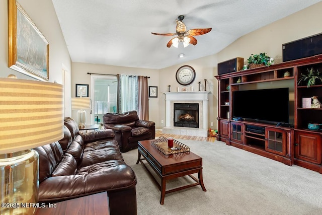 carpeted living room featuring a tiled fireplace and ceiling fan