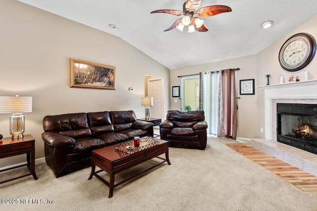 living area featuring a tile fireplace, light colored carpet, a ceiling fan, and lofted ceiling