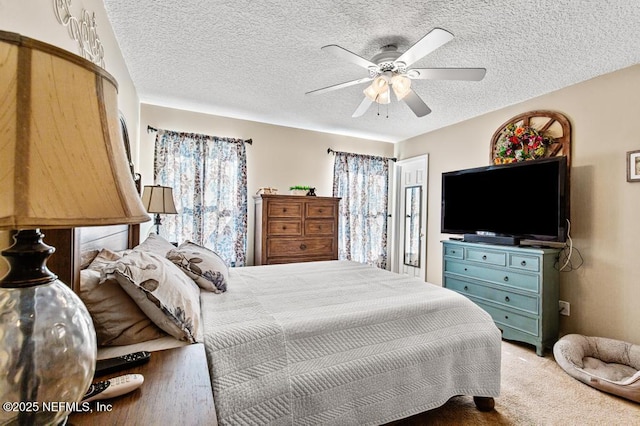 bedroom with carpet floors, a ceiling fan, and a textured ceiling