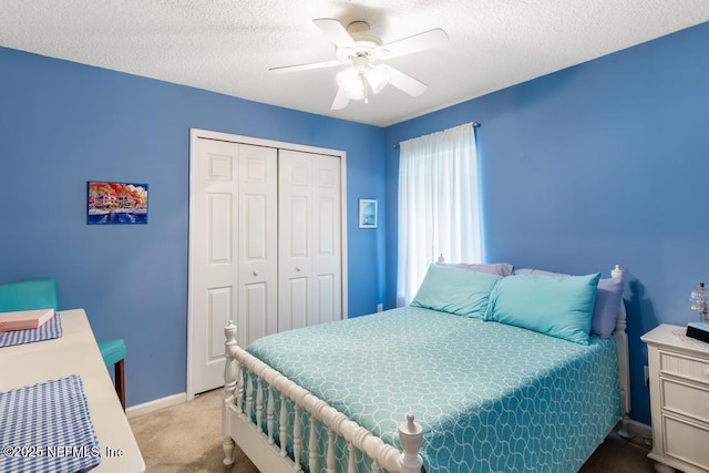 bedroom featuring a closet, baseboards, a ceiling fan, a textured ceiling, and carpet flooring
